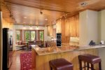 Gourmet kitchen has modern appliances and cupboards, with both bar and table seating